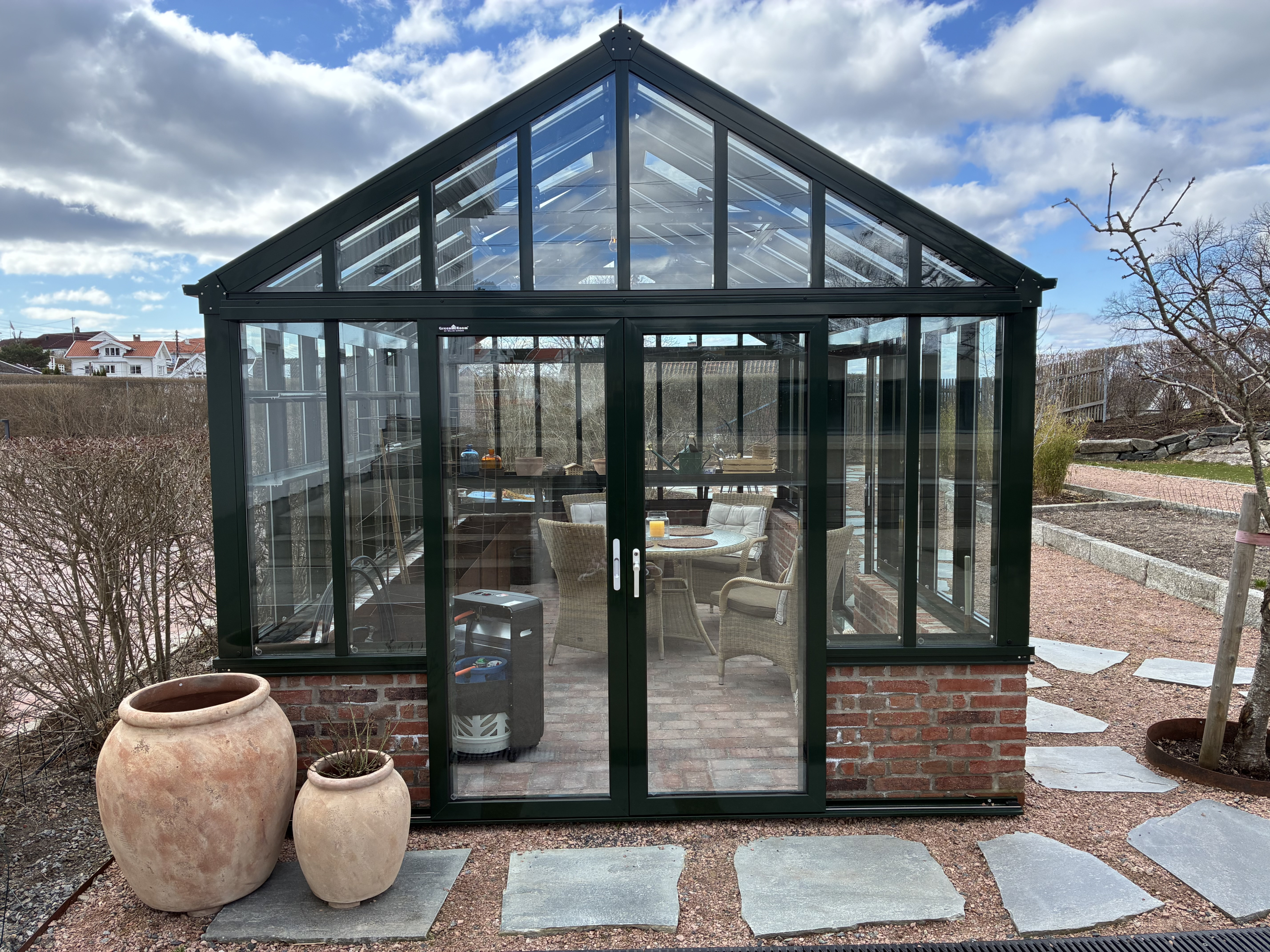 Detaljbilde av drivhus og tilhørende kjøkkenhage med granitt-detaljer i en totalrenovert hage i Moss.